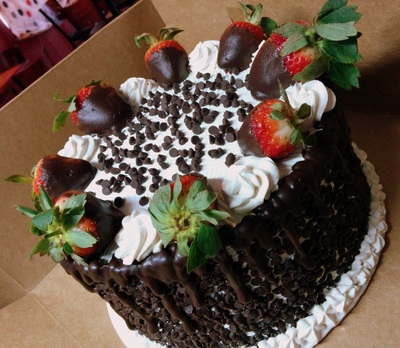 Chocolate cake topped with chocolate covered strawberries