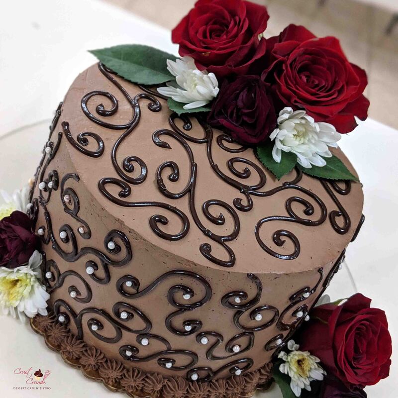 Chocolate whipped cream frosting with ganache swirls and fresh red roses cake